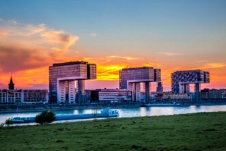 Kranhäuser im Sonnenuntergang und Rheinwiese