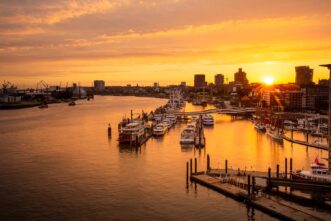 Hamburg: Blick von der Elbphilharmonie auf das Hafengebiet und den Fischmarkt im Sonnenuntergang.