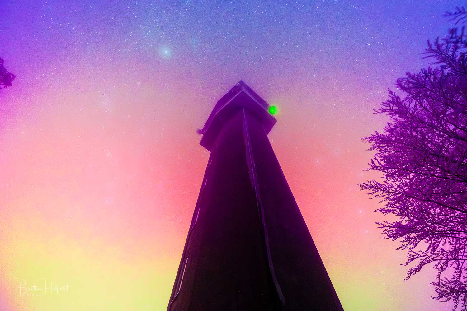 Westerwald: Der Köppelturm im Polarlicht. Eine steile Perspektive nach oben in den bunten Himmel.