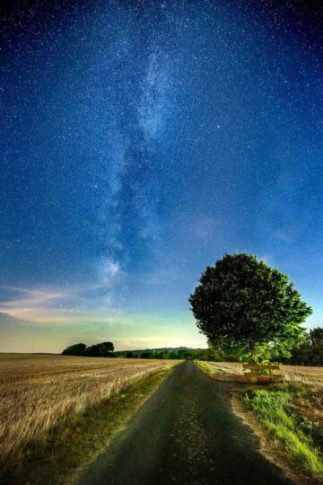 Milchstraße über einem Feld im Westerwald bei sichtbarer Lichtverschmutzung aus Richtung Montabaur