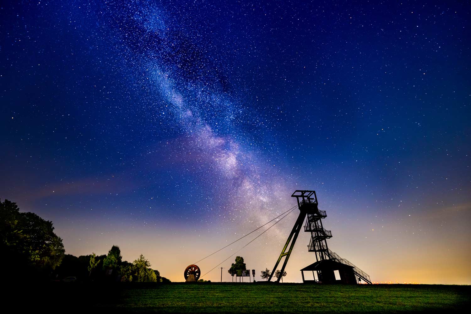 Milchstraße über dem alten Förderturm, dem Barbaraturm im Westerwald, der silhouettenartig am Horizont erscheint.