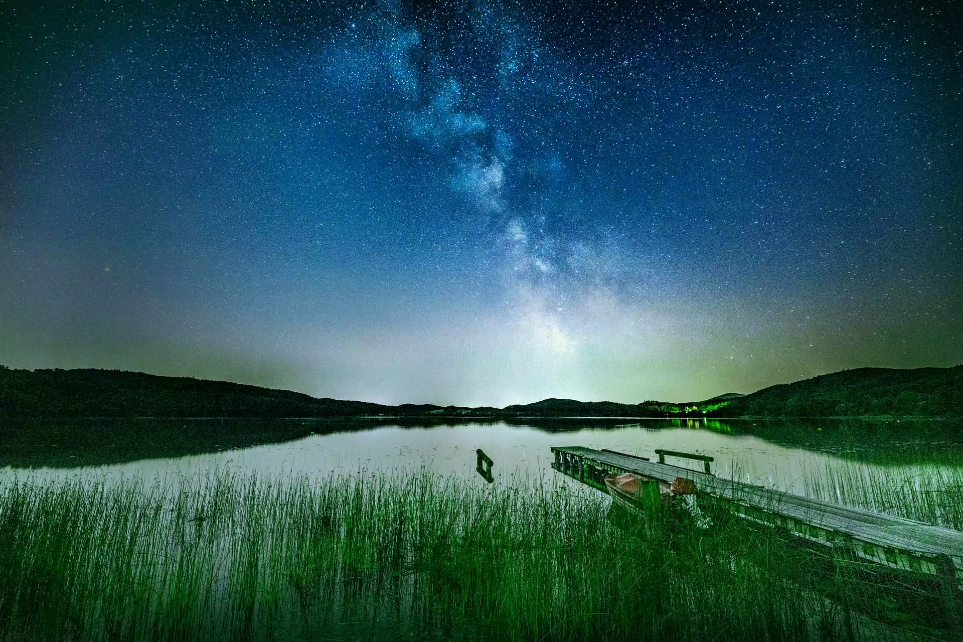 Milchstraße über dem Laacher See in der Eifel mit Steg und Spiegelung